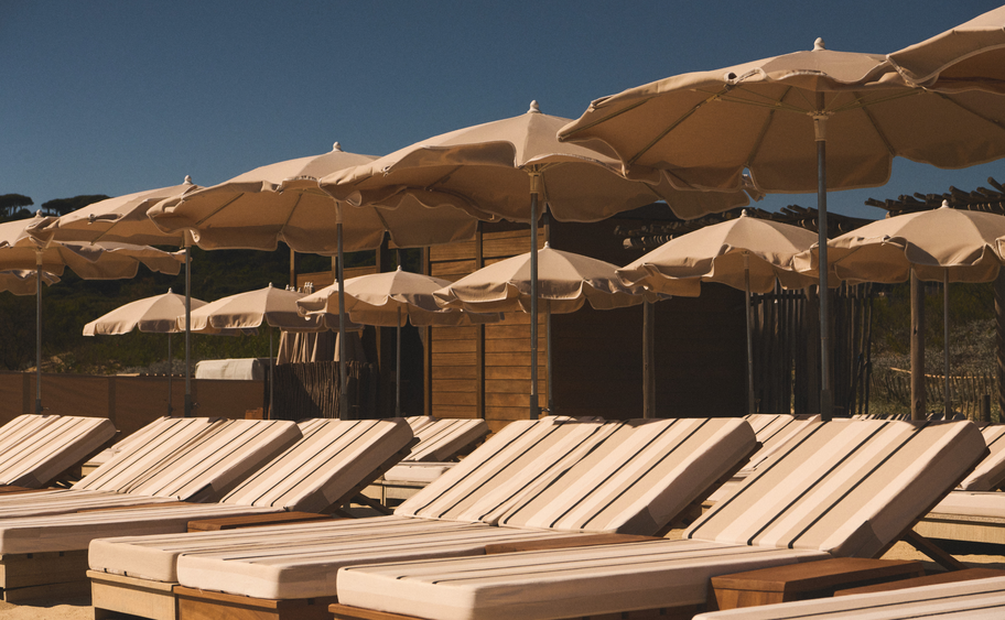 Transats et parasols blancs face &agrave; la mer bleue avec voilier &ndash; plage Indie Beach, Pampelonne golfe Saint-Tropez