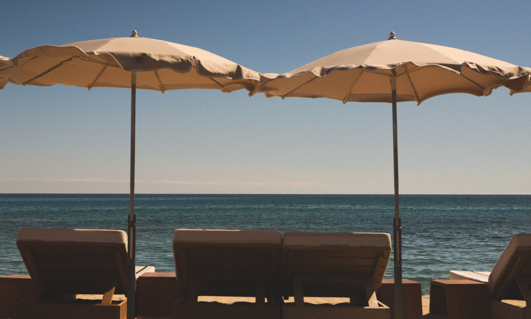 Vue d'ensemble des transats Indie Beach avec colline et mer en fond &ndash; plage de Pampelonne, Ramatuelle